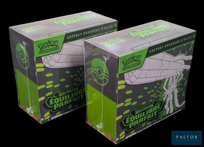 two boxes of green and white paper are sitting on a black surface