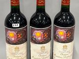 trois bouteilles de vin rouge posées côte à côte sur une table