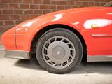 a red car that is parked in front of a brick wall