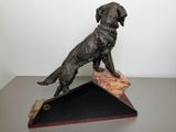 statue of a dog sitting on top of a wooden block
