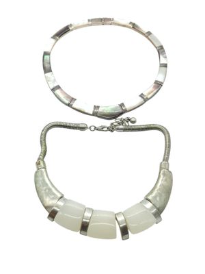 two pieces of silver and mother of pearl jewelry on a white background