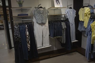 a lot of clothes hanging on a rack in a store
