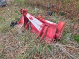 un tracteur rouge qui est couché dans l'herbe