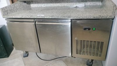 a counter with a sink and a refrigerator in it