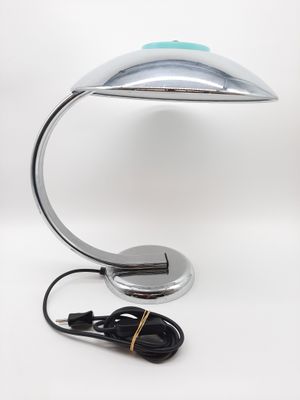 une lampe de bureau argentée surmontée d'une lumière bleue