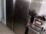 a large stainless steel refrigerator in a kitchen with a lot of clutter