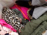 a pile of clothes that is sitting on a bed
