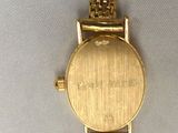 a close up of a gold watch with a chain around it