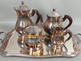 a silver tray with a silver tea set on it