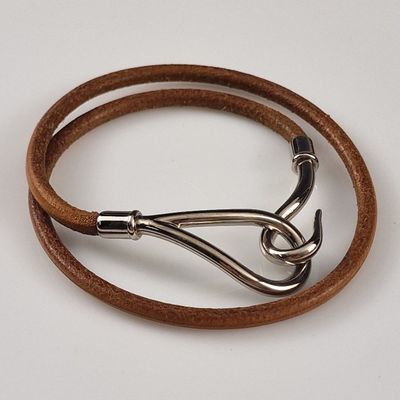 bracelet en cuir marron muni d'un fermoir argenté, sur fond blanc
