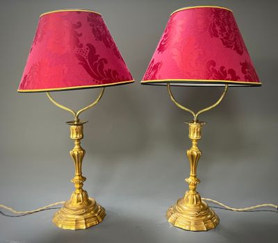 une paire de lampes de table en laiton avec des abat-jours roses et un abat-jour rouge