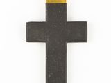 a black and gold cross hanging on a white wall