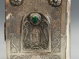 an antique silver box with a green stone in the middle