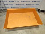 a close up of a yellow tray on a floor near a wall