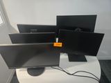 three monitors sitting on a table in front of a window