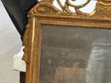 a gold framed mirror sitting on top of a table