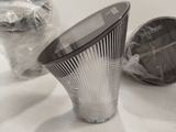 a silver vase sitting on top of a table next to other items