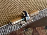 a silver box with a ring on it sitting on a table