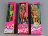 three barbie dolls are lined up in a row on a table