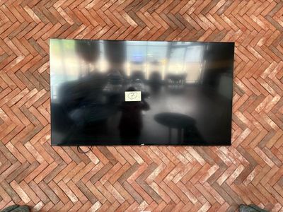 un téléviseur fixé à un mur en briques dans un salon