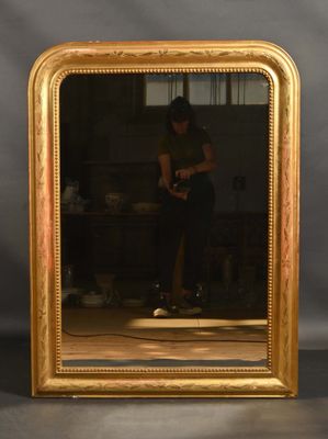 le reflet d'une femme dans un miroir accroché au mur