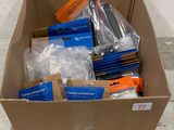une boîte en carton remplie d'objets divers, posée par terre