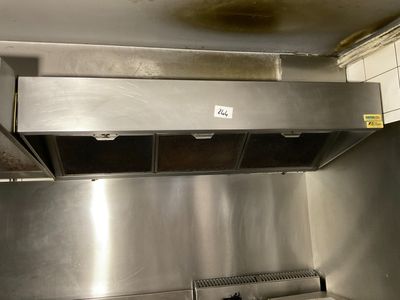 a stainless steel kitchen with a stove and a range hood