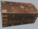 an old wooden box with gold decorations on it on a gray background