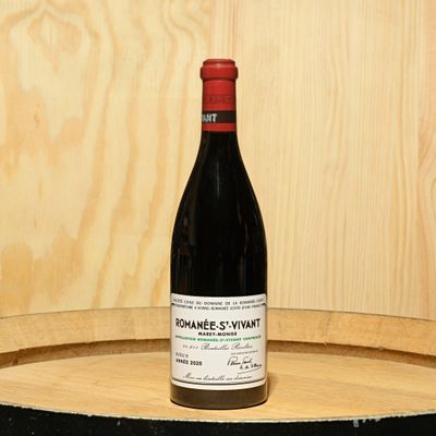 a bottle of wine sitting on top of a barrel