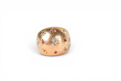 un gros plan sur une bague en or sertie de diamants roses et blancs