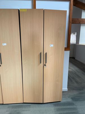 three wooden cabinets in a room with a gray floor