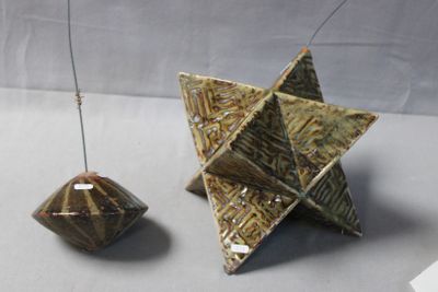 two pieces of art that are sitting on a table