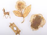 three gold brooches, a deer, and a leaf