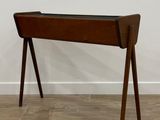 une photo d'un bureau en bois avec un plateau en verre, posé sur un parquet en bois massif