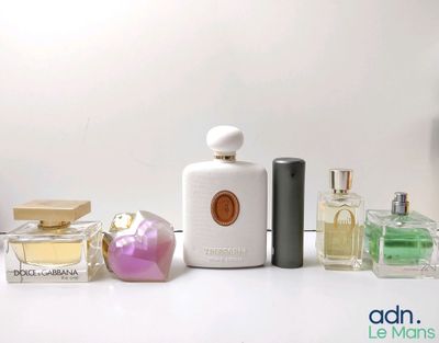 many different types of perfumes on a white table