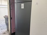 un réfrigérateur qui se trouve dans un garage dont la porte est ouverte