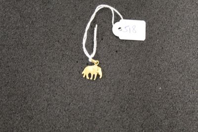 a necklace with a gold elephant on it on a black surface