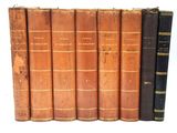 plusieurs vieux livres sont alignés sur une surface blanche