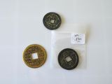 deux pièces chinoises et une pièce chinoise sont posées sur une surface blanche
