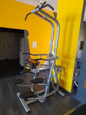 un mur jaune derrière les appareils de musculation de la salle de sport