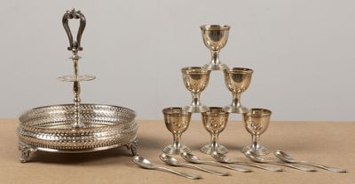 un plateau en argent avec des tasses et des cuillères en argent posées sur une table