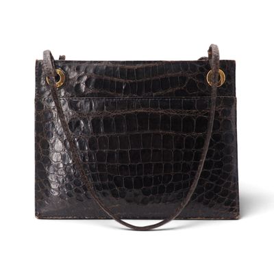 un sac à main en cuir de crocodile noir sur fond blanc