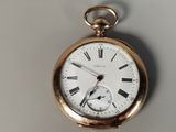 a gold pocket watch with roman numerals on the face