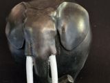 statue d'un éléphant avec des défenses sur fond noir