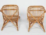 pair of wicker chairs with arms and legs in the shape of a basket