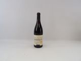 la bouteille de vin est posée sur une surface blanche