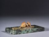 a bronze sculpture of a mouse on a marble base