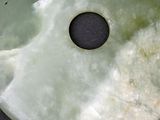 a picture of a green jade disc with a hole in it