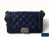 the small blue bag is sitting on a white surface