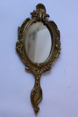 un miroir avec un cadre doré posé sur une table blanche